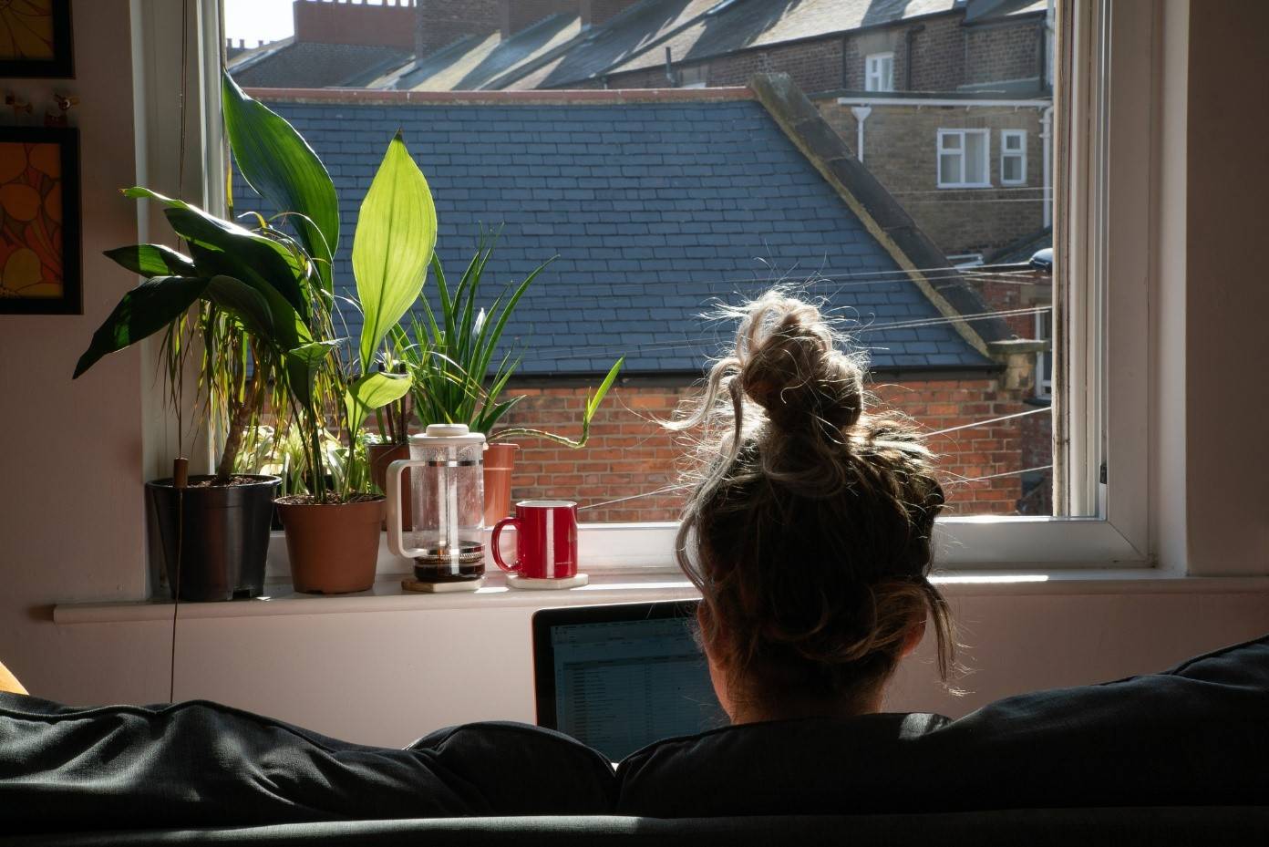 woman working on laptop looking out window